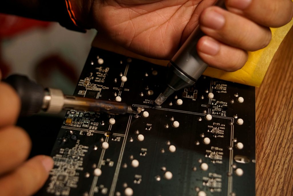 A close up of a person working on a circuit board